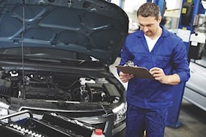 repair tech with car and clipboard