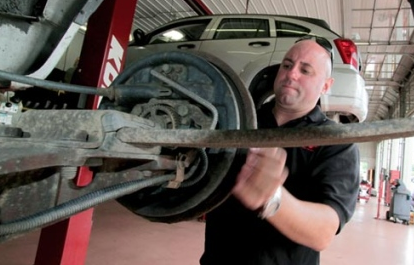 Vince Rinaldi, store manager at Kost Tire and Auto Service at 398 N. Ninth Ave. in Scranton, removes a brake drum to check brake pads during a state car inspection on Monday. Pennsylvania still requires annual vehicle inspections, but New Jersey this month eliminated its biennial checkups - a move that safety advocates say isn't a good idea.